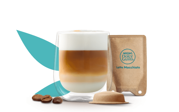 Copo com a bebida neo latte macchiato com a cápsula e saqueta de papel ao lado