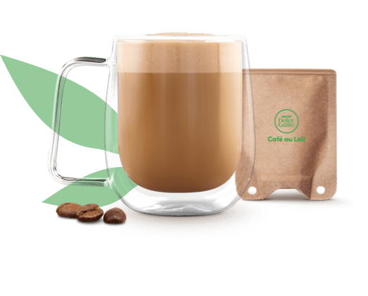 Caf&eacute; com leite numa caneca ao lado de uma saqueta