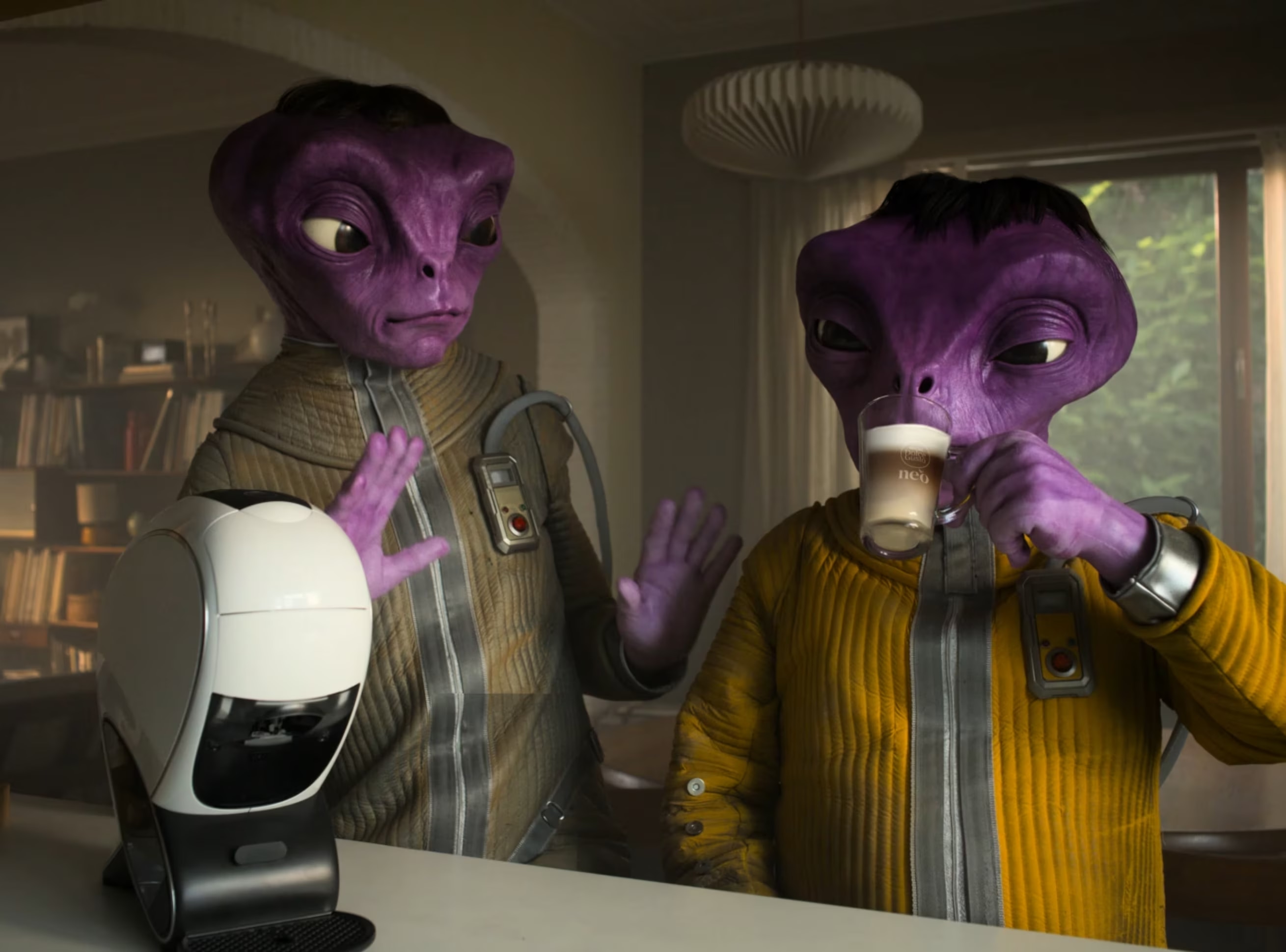 Miniatura de vídeo da campanha NEO Latte, com a máquina NEO Latte e duas figuras alienígenas.