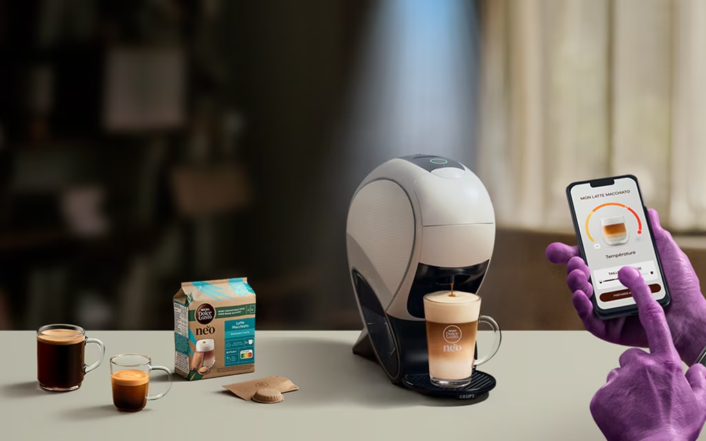 Uma mão alienígena a usar a aplicação NESCAFÉ® Dolce Gusto® para personalizar o seu café. NEO, máquina smart latte, pack de café e bebidas.