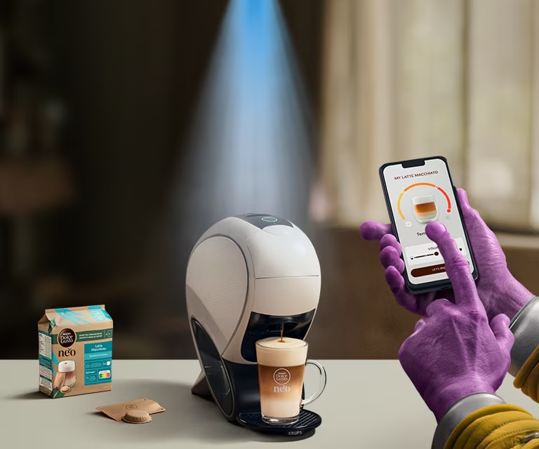 Uma mão alienígena a usar a aplicação NESCAFÉ® Dolce Gusto® para personalizar o seu café. NEO, máquina smart latte, pack de café e bebidas.