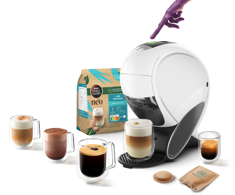 Dedo de alien&iacute;gena a tocar na NEO Latte, com bebidas, pack NEO, c&aacute;psula e saqueta ao redor.