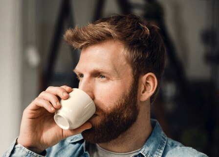 Homem a beber café expresso