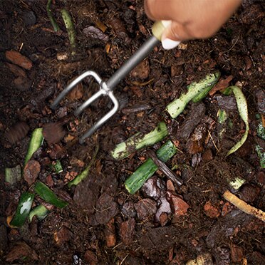 Pá e restos orgânicos no composto