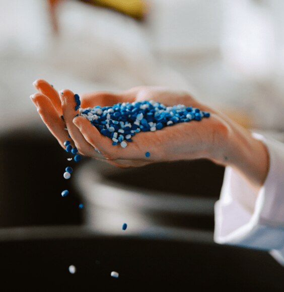 Mão segurando grânulos azuis e brancos